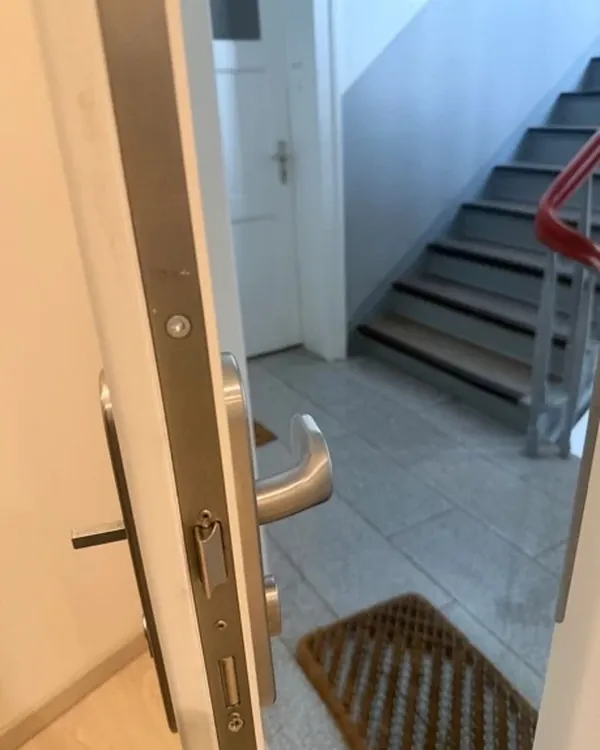 Geöffnete Wohnungstür zum Treppenhaus eines Mehrfamilienhauses